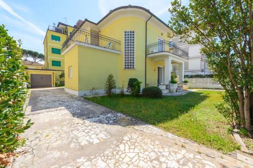 a large yellow house with a driveway at Golden Luxe - Roman Luxury Villa in the Sea in Camaiore