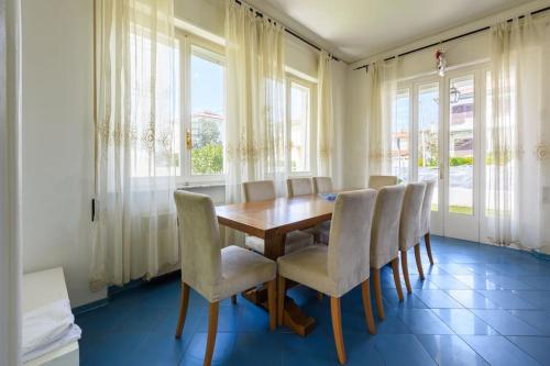 a dining room with a wooden table and chairs at Golden Luxe - Roman Luxury Villa in the Sea in Camaiore