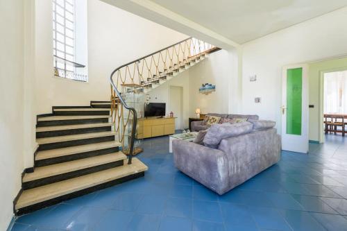 a living room with a staircase and a couch at Golden Luxe - Roman Luxury Villa in the Sea in Camaiore