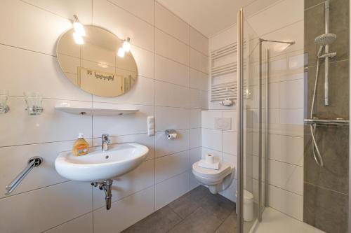 a bathroom with a sink and a toilet and a mirror at Haus Boje Haus Boje 3 in Schillig