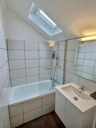 une salle de bain avec une baignoire et un lavabo dans l'établissement WonderHost, spacieux et atypique en coeur de ville, à Pau