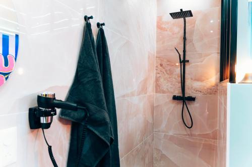 a shower in a bathroom with a black umbrella at Capsule Bonbon - Balneo - Sauna - Billard - Nintendo Switch in Douai