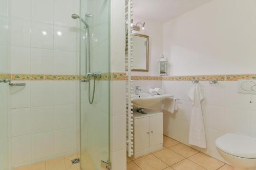 a bathroom with a shower and a toilet and a sink at Landhaus auf der Düne, App 2 in Rantum
