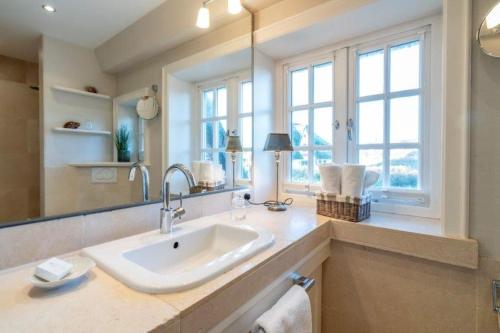 Godewind Haus Godewind, GO02 في رانتوم: حمام مع حوض ومرآة كبيرة