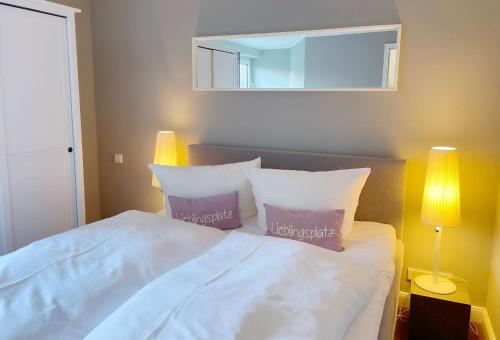 a bedroom with a bed with two pillows and a mirror at Friesenhof, fr 02 in Rantum