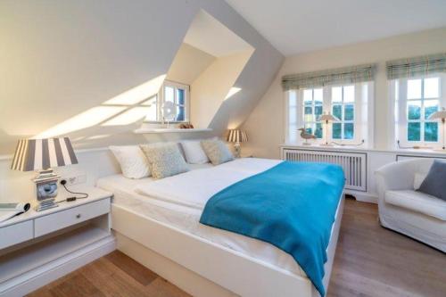 Godewind Haus Godewind, GO02 في رانتوم: غرفة نوم بيضاء بسرير وكرسي