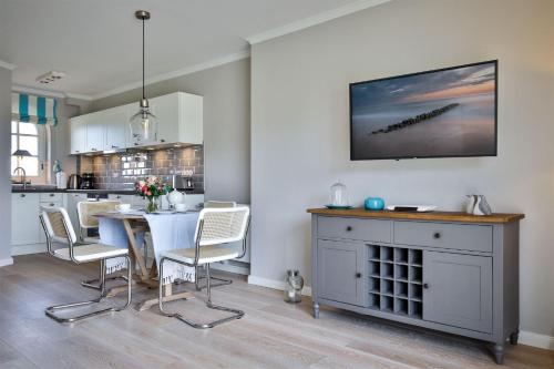 a kitchen and dining room with a table and chairs at Heefkant Haus Heefkant,HK 02 in Rantum