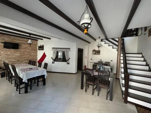 a dining room with a table and chairs and a staircase at Pensiunea Rustic in Borşa