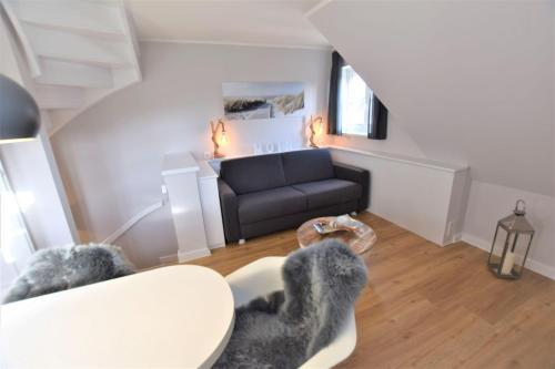 a living room with a couch and a table at Warfthüs App 08 in Rantum