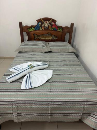 two beds with white napkins and utensils on them at Pousada Vilasboas in Parintins
