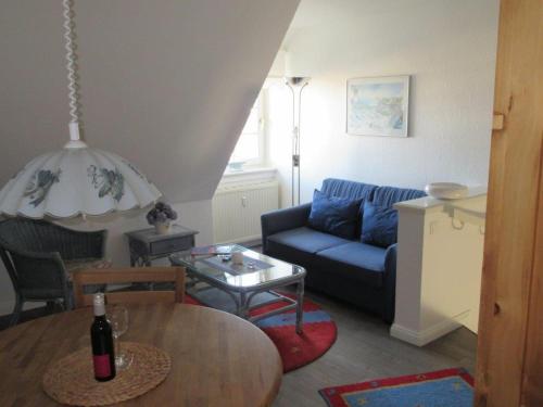 a living room with a blue couch and a table at Wattblick Haus Wattblick "Wattglück" in Rantum