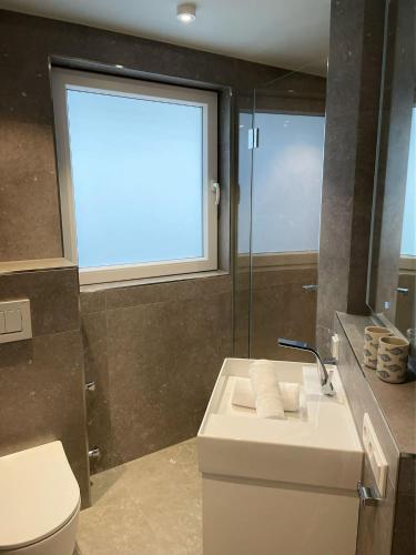 a bathroom with a sink and a toilet and a window at Warfthüs, App 1 in Rantum