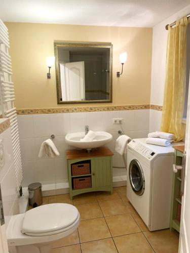 ein Badezimmer mit Waschmaschine und Waschbecken in der Unterkunft Landhaus am Watt in Rantum