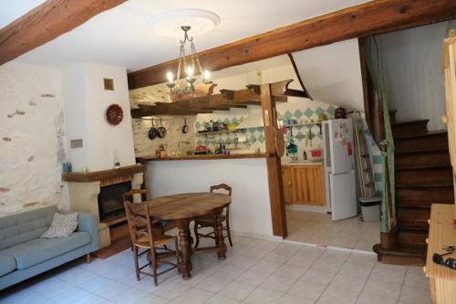 un salon avec une table et une cuisine dans l'établissement Charmante Maison de Village dans les fenouilledes, à Cassagnes