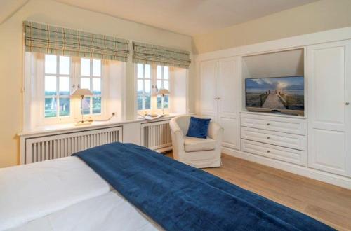 une chambre avec un lit, une chaise et des fenêtres dans l'établissement Godewind Haus Godewind, GO01, à Rantum