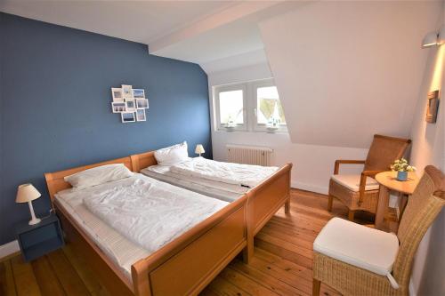 a bedroom with a bed with a blue wall at Marmelbloom in Rantum