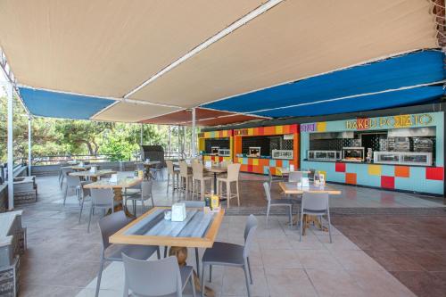 a restaurant with tables and chairs and a cafeteria at Megasaray Resort Side in Side