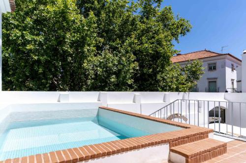 a swimming pool on the side of a building at Limehome Evora Largo dos Penedos in Évora