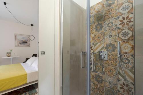- une douche avec une porte en verre dans la chambre dans l'établissement Taormina Suite Downtown, à Taormine