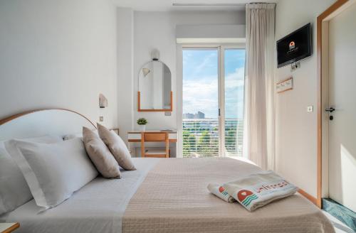 a bedroom with a bed with a large window at Hotel Universal in Cattolica