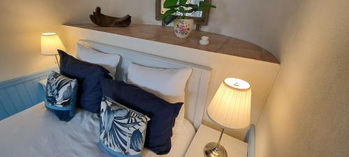 a bedroom with a bed with blue and white pillows at La Vernassonne in Alzonne