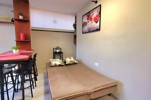 a small room with a bench next to a table at Apartamento 15 - (850 mt do Centro) - 2 Banheiros in Poços de Caldas