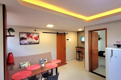a dining room with a table and a kitchen at Apartamento 15 - (850 mt do Centro) - 2 Banheiros in Poços de Caldas