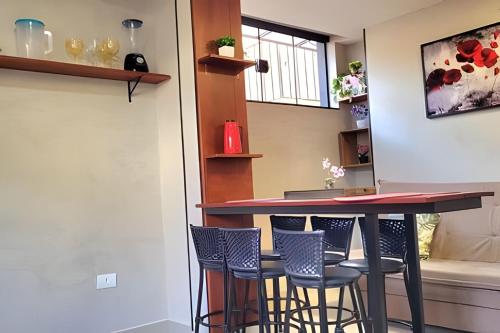 a bar in a kitchen with stools at Apartamento 15 - (850 mt do Centro) - 2 Banheiros in Poços de Caldas