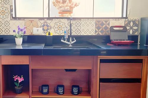 a kitchen with a sink and a counter top at Apartamento 15 - (850 mt do Centro) - 2 Banheiros in Poços de Caldas