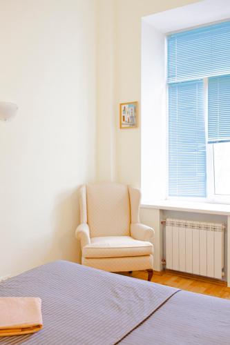 a bedroom with a bed and a chair and a window at Апартаменти 3-кімнатні в центрі, метро Театральна in Kyiv