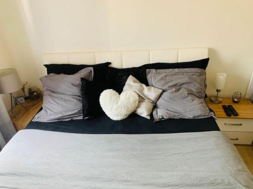 - un lit avec des oreillers et un oreiller pour le cœur dans l'établissement T2 Stade de France - Porte de Paris, à Saint-Denis
