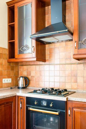 a kitchen with a black stove and wooden cabinets at Апартаменти 3-кімнатні в центрі, метро Театральна in Kyiv