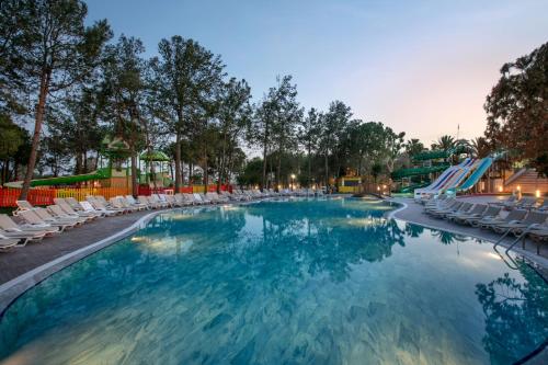 a swimming pool with lounge chairs and a resort at Megasaray Resort Side in Side