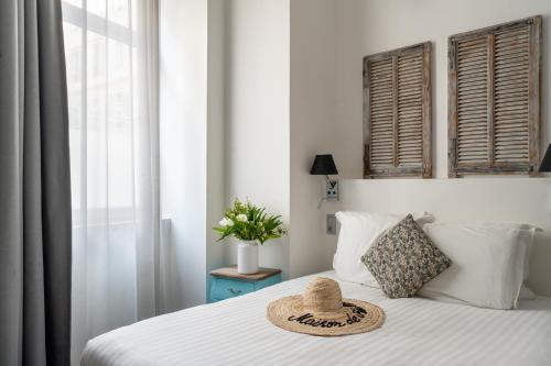 a straw hat sitting on top of a bed at Hotel La Villa Nice Promenade in Nice