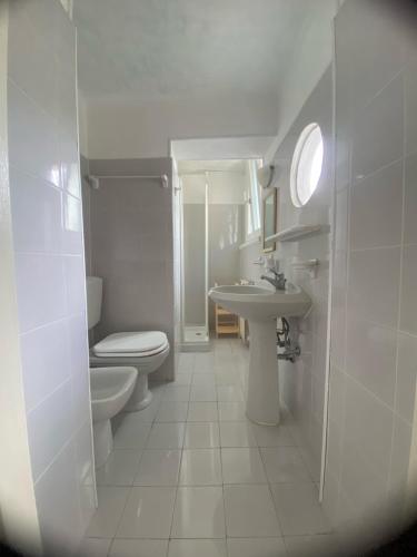 a white bathroom with a toilet and a sink at Foresteria Lombarda B & B Ca' Pelitti in Ganna