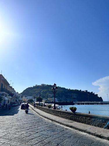 a cobblestone street next to a body of water at Al Capitello in Lacco Ameno