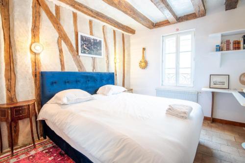 une chambre avec un grand lit avec une tête de lit bleue dans l'établissement La Demeure Médiévale - Maison 4pers. Amboise, à Amboise
