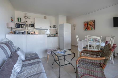 une cuisine et un salon avec un canapé et une table dans l'établissement Bord de mer, rez-de-terrasse pour 4, Pornic, à Pornic