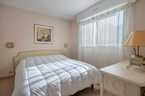 a bedroom with a white bed and a window at Bord de mer, rez-de-terrasse pour 4, Pornic in La Birochere