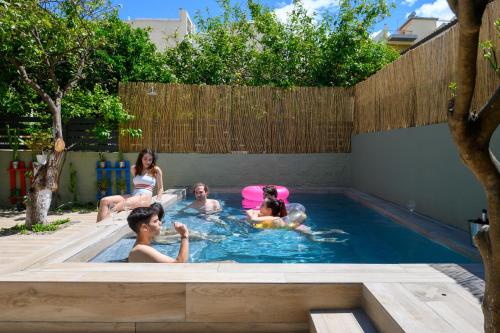 a group of people in a swimming pool at City Cottage - Kalamata Villas in Kalamata