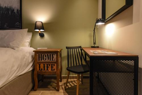 a bedroom with a desk and a bed and a chair at City Cottage - Kalamata Villas in Kalamata
