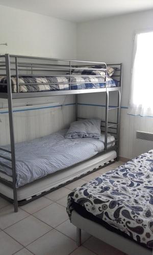 deux lits superposés dans une chambre avec un lit dans l'établissement maison récente proche forêt et bord de mer, à Saint-Jean-de-Monts