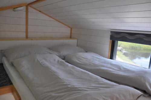 two beds in a small room with a window at Café-Pension Kristall in Harbach