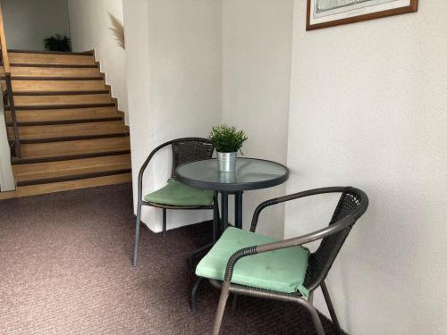 a table and chairs in a room with a staircase at Penzion Zelený Háj in Merklín