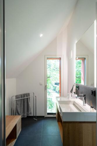a white bathroom with a sink and a mirror at Haus Riga in Prerow