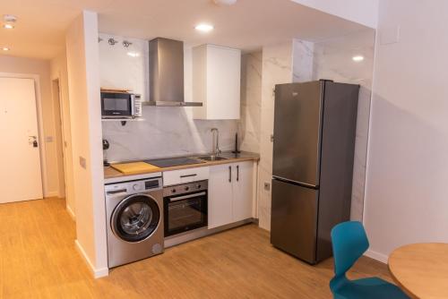 YuncosにあるApartamentos Hotel Carlos Iのステンレス製の冷蔵庫とコンロを備えたキッチン