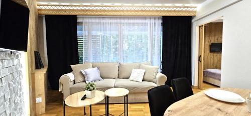 a living room with a couch and a table at VIP Apartamenty Stara Polana 2 in Zakopane