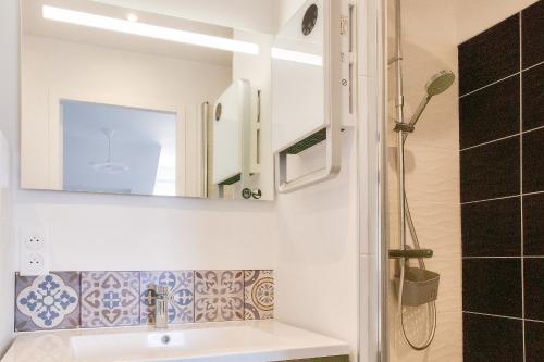 une salle de bain avec un lavabo et un miroir dans l'établissement À 230m de la plage - Bel appartement pour 4, à Fouesnant