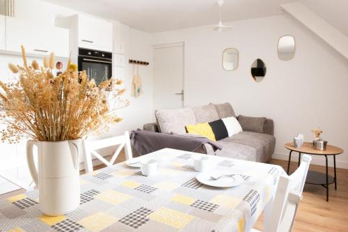 un salon avec une table et un canapé dans l'établissement À 230m de la plage - Bel appartement pour 4, à Fouesnant