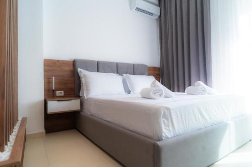 シュコダルにあるEnea Room in Centerの白いシーツと枕が付いた大きなベッドのある寝室